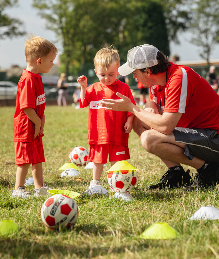a person und two children playing football